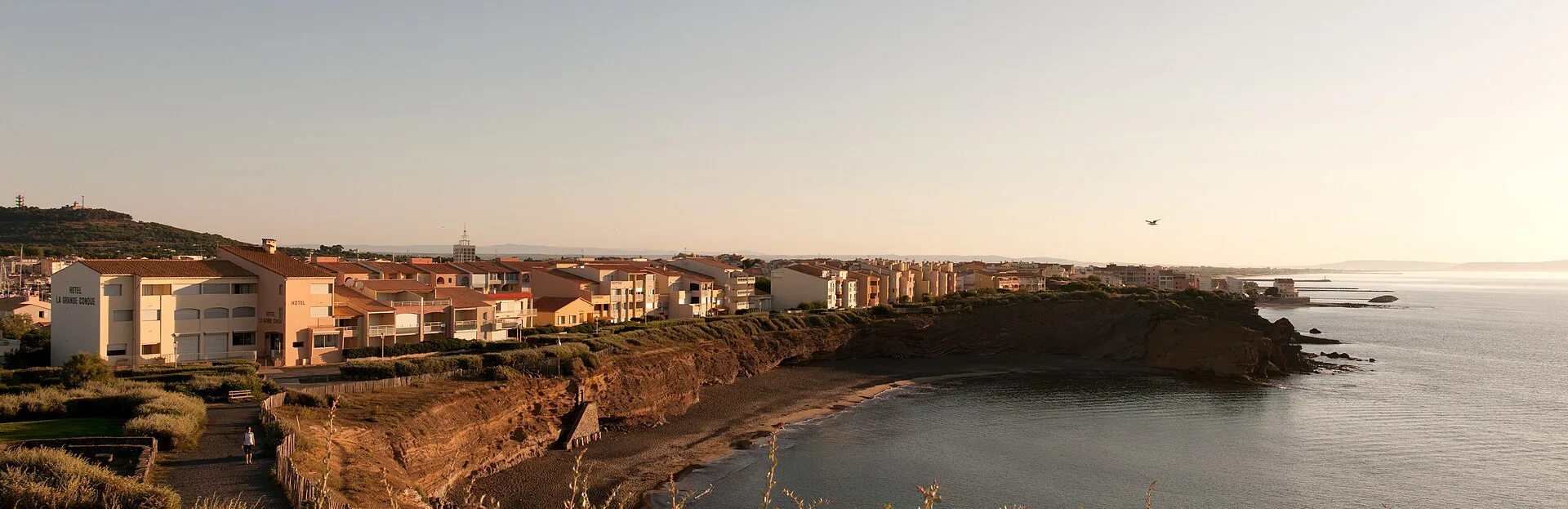 Vue sur le port du Cap d'Agde avec ses bateaux et la falaise volcanique en arrière-plan
