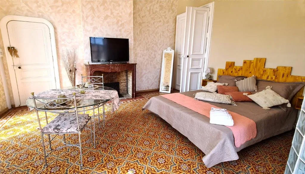 Chambre Mille Mandolines — cheminée, tomettes rouges et lumière du sud